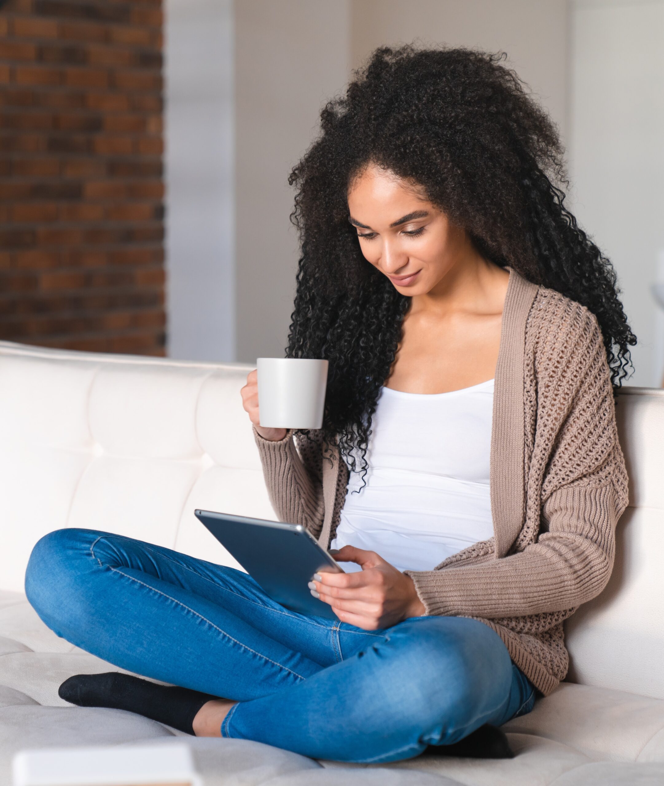 Happy relaxed young african woman freelancer student tutor using digital tablet for online shopping, scrolling social media, e-learning, e-commerce, reading e-book